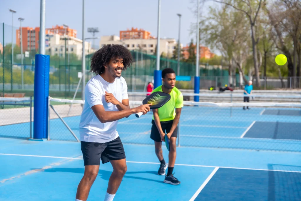 friends enjoying playing pickleball together outdoor court